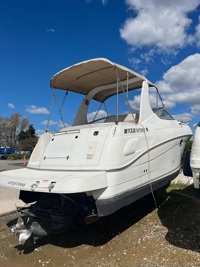 Slide: The Image of 2003 Four Winns 268 Vista boat with canopy under a clear blue sky. - 1