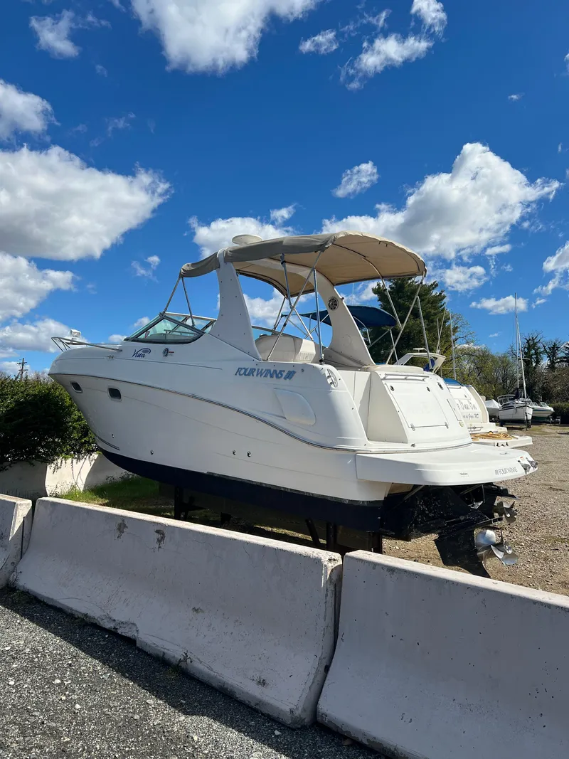 Slide: The Image of 2003 Four Winns 268 Vista boat on dry dock under a clear blue sky. - 10