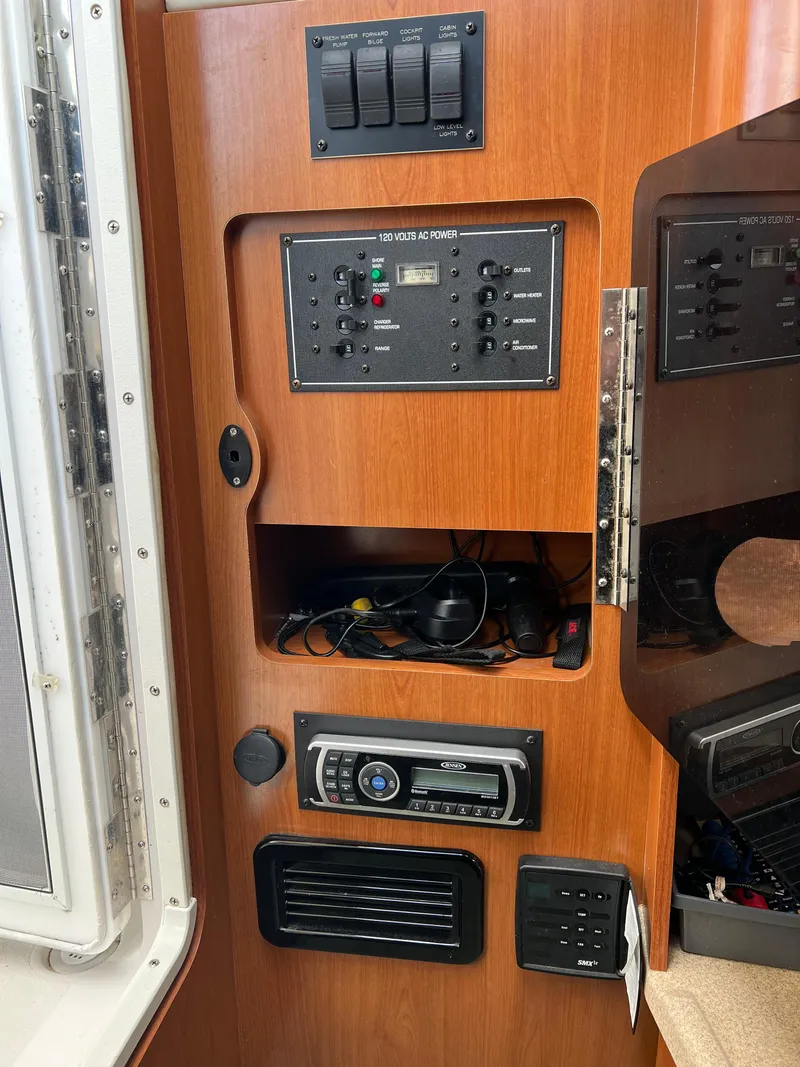 Slide: The Image of 2003 Four Winns 268 Vista control panel with AC power switches and stereo system. - 29