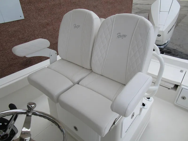 Slide: The Image of 2024 Ranger 2360 Bay boat with white cushioned seats and steering wheel. - 18