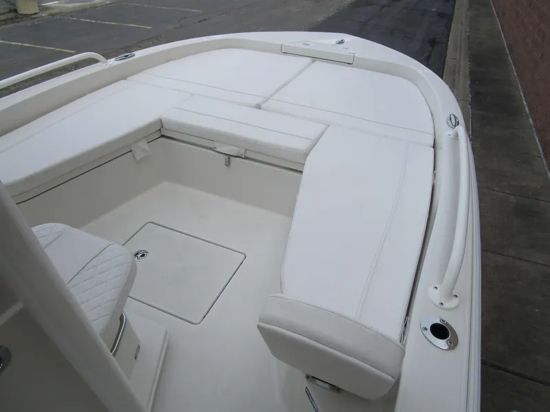 Slide: The Image of 2024 Ranger 2360 Bay boat with white cushioned seating and storage compartments. - 25