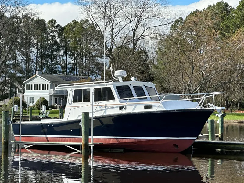 The Image of Custom 2016 Broad Creek 32 Downeast boat docked by a lakeside house. - 0