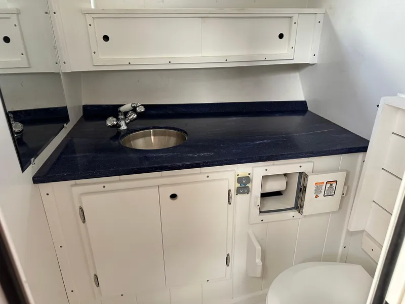 Slide: The Image of 2016 Custom Broad Creek 32 Downeast boat bathroom with sink, countertop, and storage cabinets. - 13
