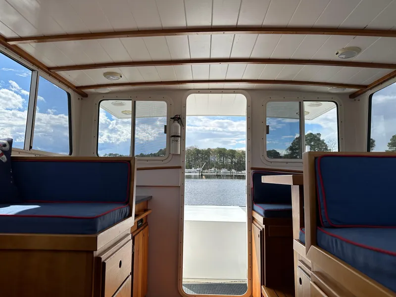 Slide: The Image of Interior view of 2016 Custom Broad Creek 32 Downeast boat with blue seating and wooden accents. - 15