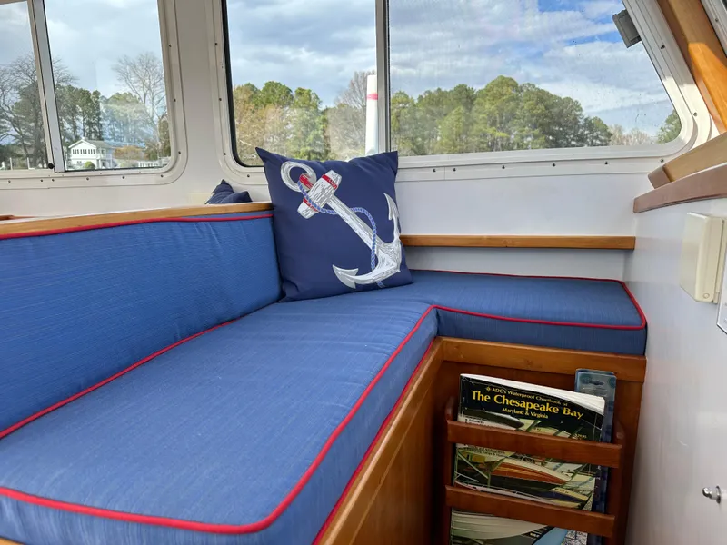 Slide: The Image of Cozy interior of 2016 Custom Broad Creek 32 Downeast with blue seating and nautical decor. - 16