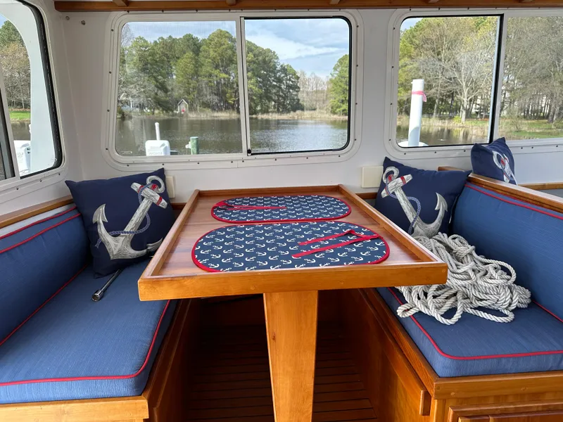 Slide: The Image of Cozy 2016 Broad Creek 32 Downeast boat interior with nautical decor and scenic window view. - 17