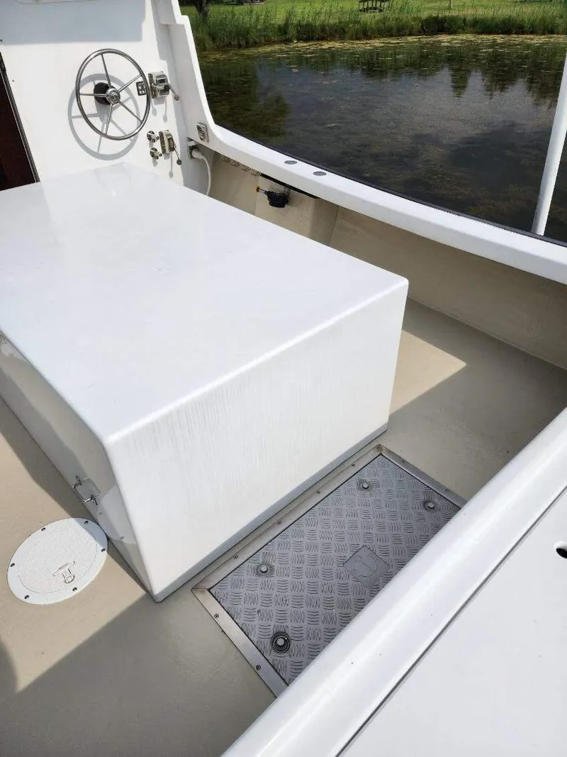 Slide: The Image of 2016 Custom Broad Creek 32 Downeast boat interior with steering wheel and storage compartment. - 20