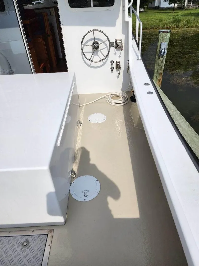 Slide: The Image of 2016 Custom Broad Creek 32 Downeast boat deck with steering wheel and clean layout. - 21