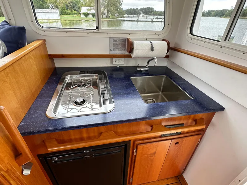 Slide: The Image of Compact kitchen area in 2016 Custom Broad Creek 32 Downeast boat with stove and sink. - 28