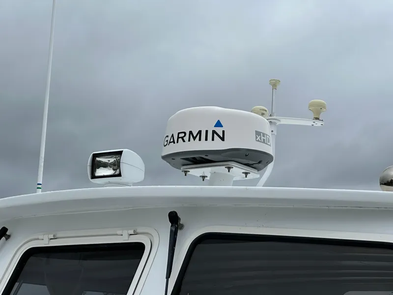 Slide: The Image of Garmin radar on 2016 Custom Broad Creek 32 Downeast boat against cloudy sky. - 29