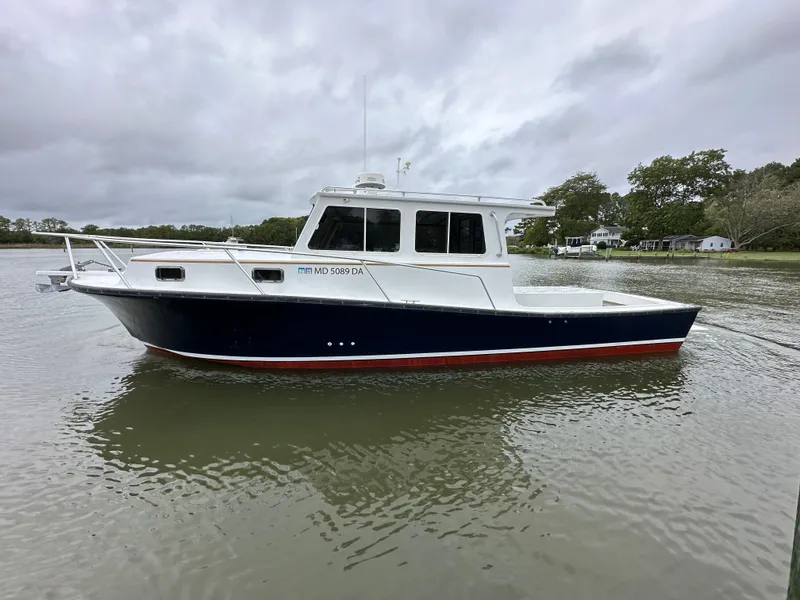 Slide: The Image of 2016 Custom Broad Creek 32 Downeast boat on calm water, overcast sky. - 34