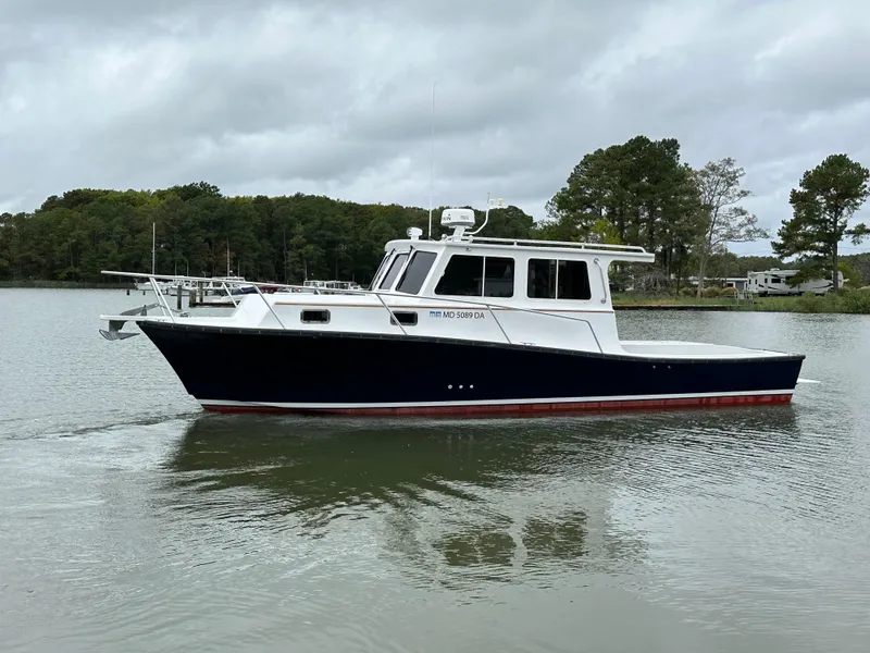 Slide: The Image of 2016 Custom Broad Creek 32 Downeast boat on calm water, overcast sky. - 35