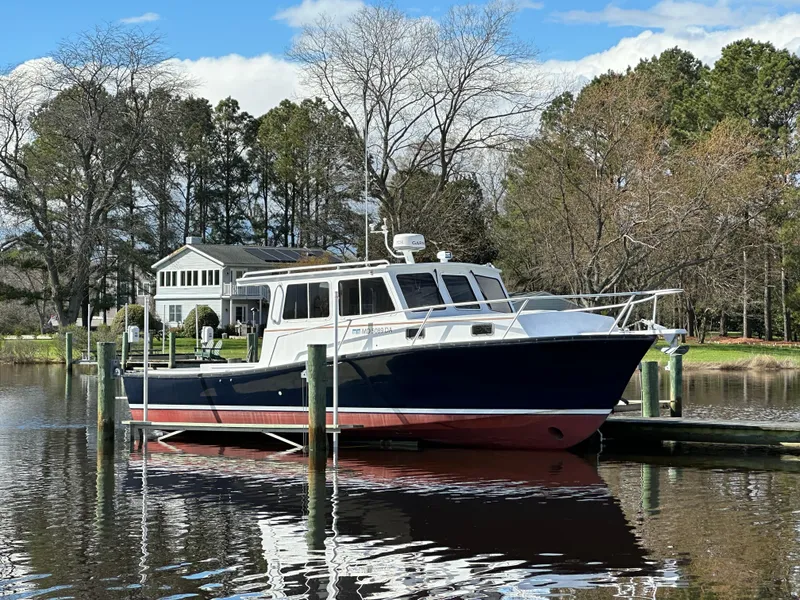 Slide: The Image of 2016 Custom Broad Creek 32 Downeast boat docked by a lakeside house. - 9