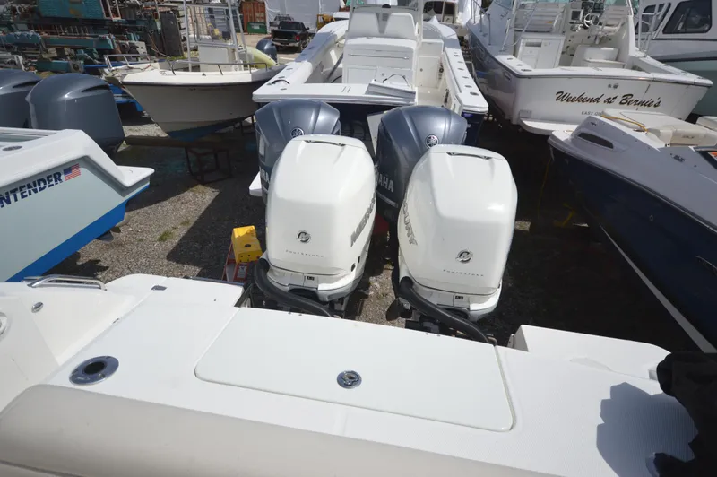 Slide: The Image of 2018 Boston Whaler 330 Outrage with dual outboard engines in a marina. - 12
