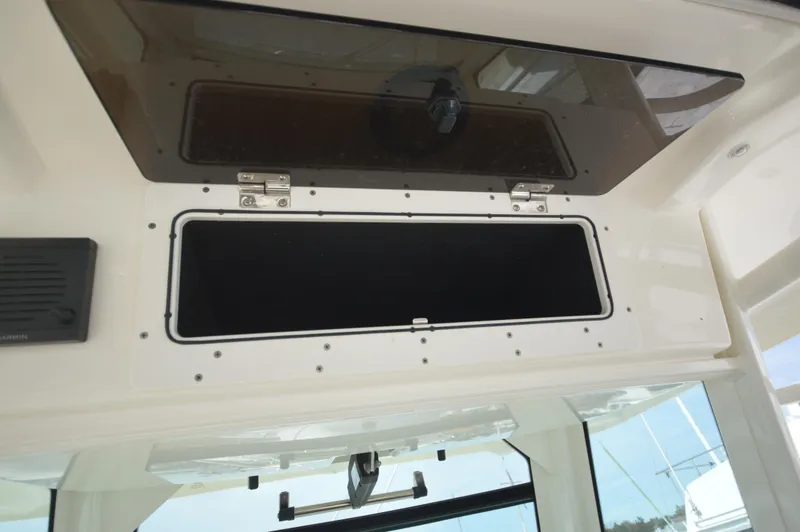 Slide: The Image of 2018 Boston Whaler 330 Outrage storage compartment with open hatch. - 17