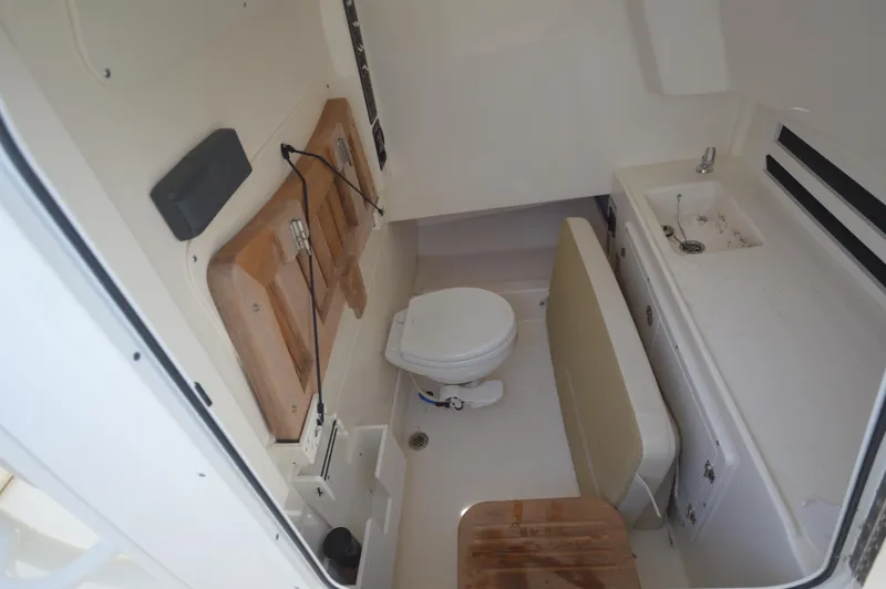 Slide: The Image of 2018 Boston Whaler 330 Outrage boat interior with toilet and sink. - 19