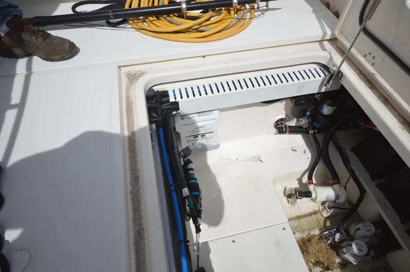 Slide: The Image of 2018 Boston Whaler 330 Outrage boat compartment with wiring and hoses. - 29