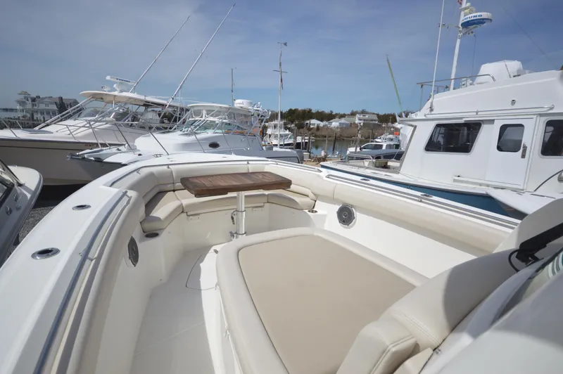 Slide: The Image of 2018 Boston Whaler 330 Outrage boat interior with cushioned seating and table. - 3