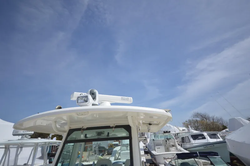 Slide: The Image of 2018 Boston Whaler 330 Outrage boat at a marina under a clear blue sky. - 7
