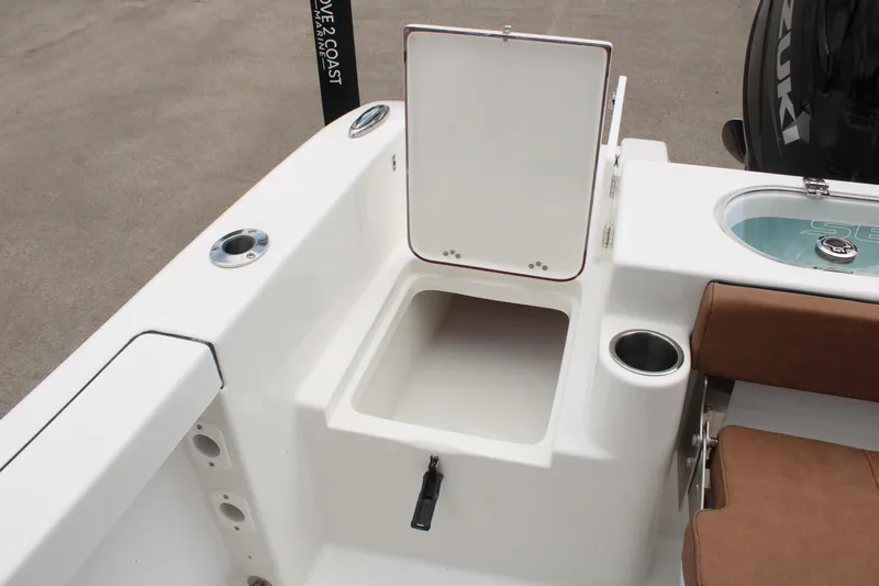 Slide: The Image of Open storage compartment on 2024 Sea Pro 222 boat with brown seating and cup holder. - 11