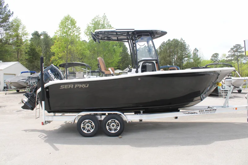 Slide: The Image of 2024 Sea Pro 222 boat on trailer, black hull, center console, outboard motor. - 2