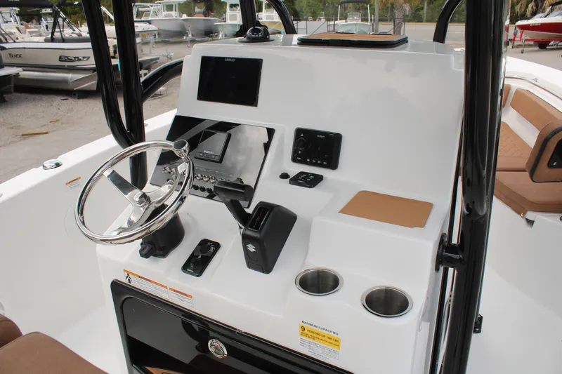 Slide: The Image of 2024 Sea Pro 222 boat console with steering wheel, controls, and cup holders. - 22
