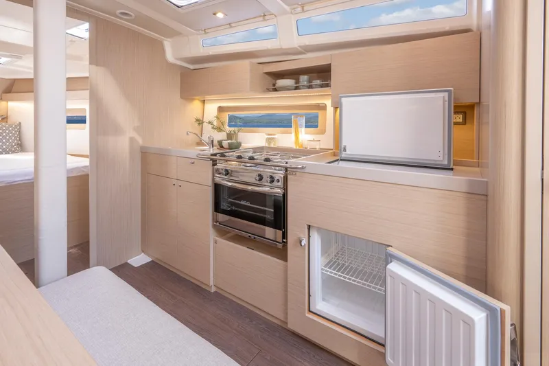 Slide: The Image of Modern kitchen interior of 2024 Beneteau Oceanis 37.1 yacht, featuring sleek cabinetry and appliances. - 13