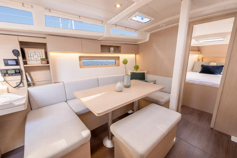 Slide: The Image of 2024 Beneteau Oceanis 37.1 interior with modern dining area and cozy seating. - 6