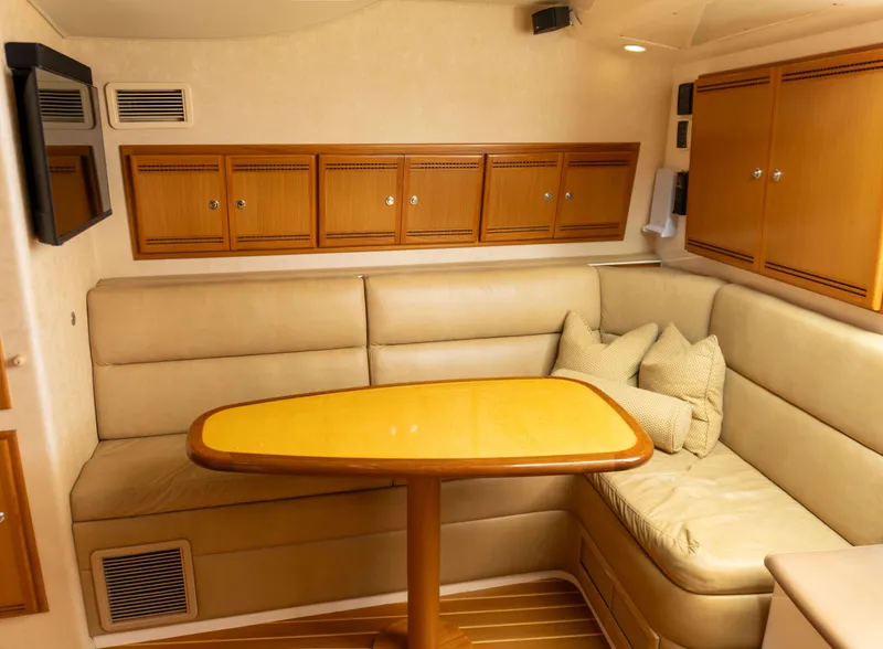 Slide: The Image of Interior of 2008 Cabo 38 Express yacht with beige seating and wooden table. - 15