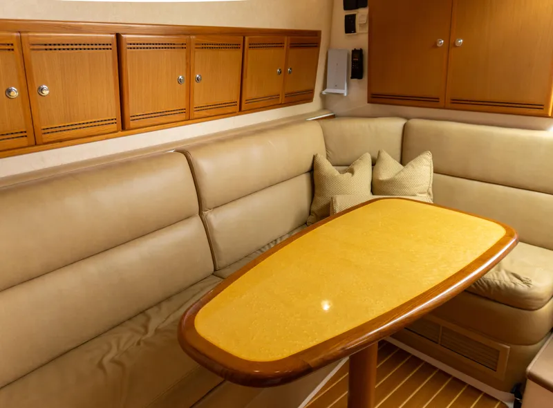 Slide: The Image of Interior of 2008 Cabo 38 Express with beige seating and wooden table. - 18