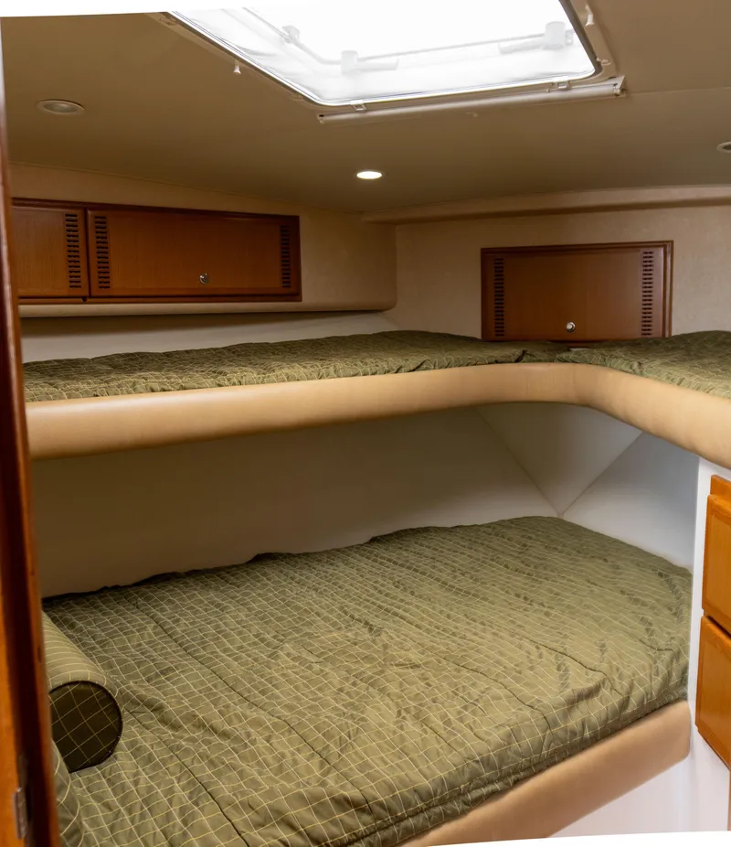 Slide: The Image of 2008 Cabo 38 Express boat interior with bunk beds and storage cabinets. - 21