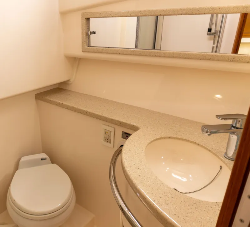 Slide: The Image of Bathroom interior of a 2008 Cabo 38 Express yacht with sink, toilet, and mirror. - 24
