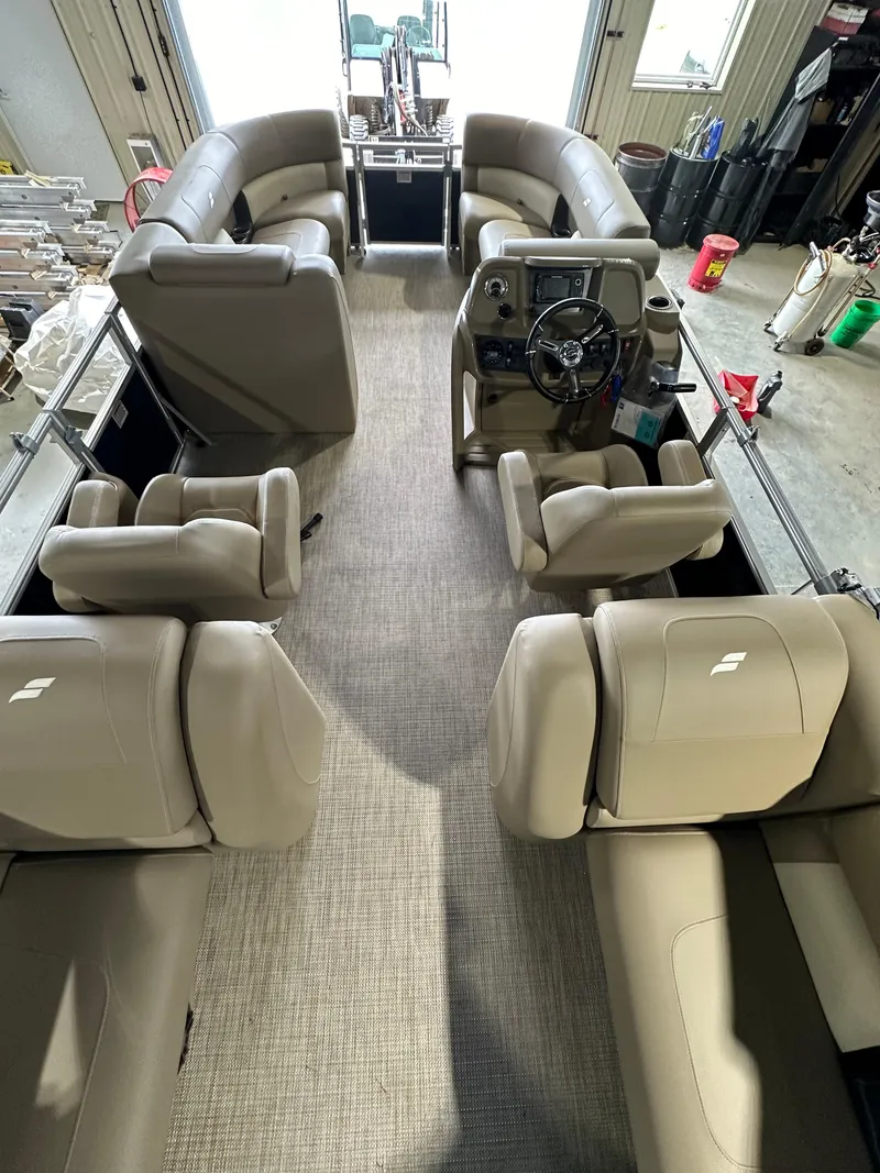 Slide: The Image of 2024 Starcraft LX22RDH pontoon boat interior with beige seating and steering console. - 3