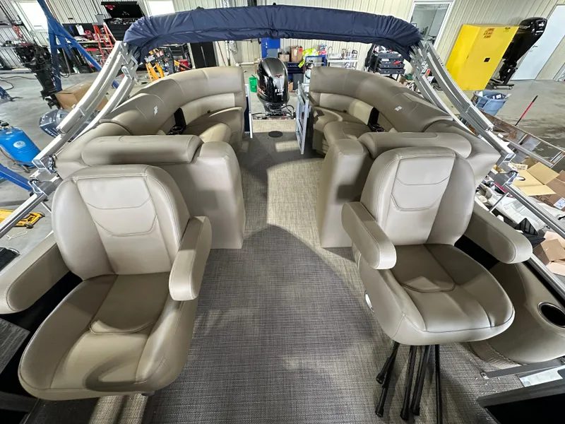 Slide: The Image of 2024 Starcraft LX22RDH pontoon boat interior with beige seating and canopy. - 6