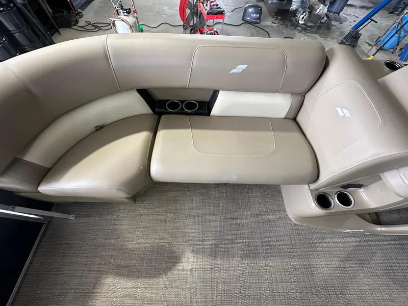 Slide: The Image of 2024 Starcraft LX22RDH boat interior with beige seating and cup holders. - 8
