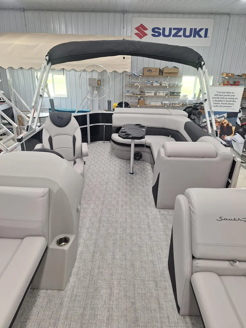 Slide: The Image of 2024 South Bay 222CRLE pontoon boat interior with seating and table. - 3