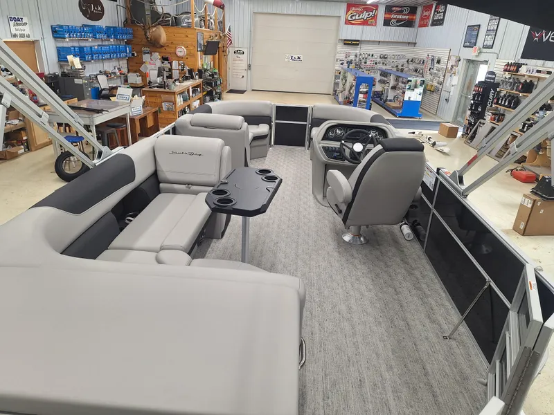 Slide: The Image of 2024 South Bay 222CRLE pontoon boat interior with seating and helm in showroom. - 4