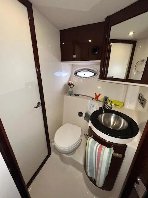 Slide: The Image of 2009 Sea Ray 40 Sundancer bathroom with modern fixtures and porthole window. - 23