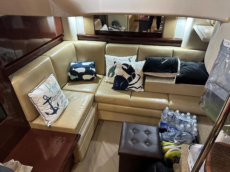 Slide: The Image of Interior of 2009 Sea Ray 40 Sundancer with beige leather seating and nautical-themed pillows. - 25
