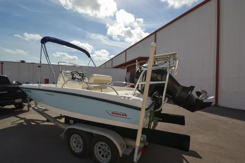 Slide: The Image of 2019 Boston Whaler 180 Dauntless boat on a trailer outside a warehouse. - 6