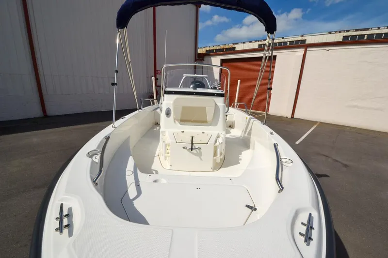 Slide: The Image of 2019 Boston Whaler 180 Dauntless boat with bimini top in a parking lot. - 9