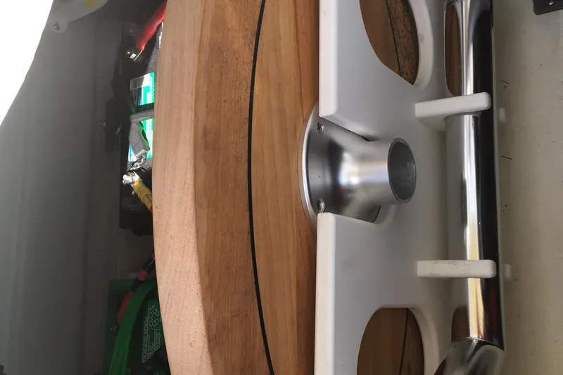 Slide: The Image of 2019 Chris-Craft Launch 27 boat interior with wooden table and storage compartment. - 13