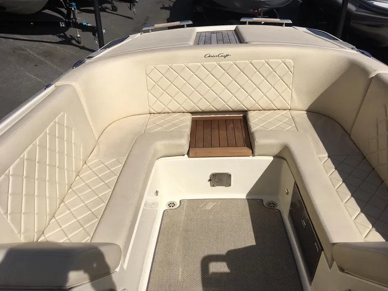 Slide: The Image of 2019 Chris-Craft Launch 27 boat interior with cream diamond-stitched seating and wooden table. - 15