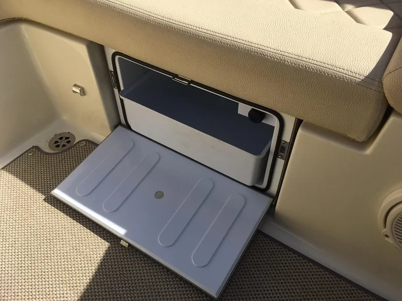 Slide: The Image of 2019 Chris-Craft Launch 27 storage compartment with beige seating and carpeted flooring. - 21