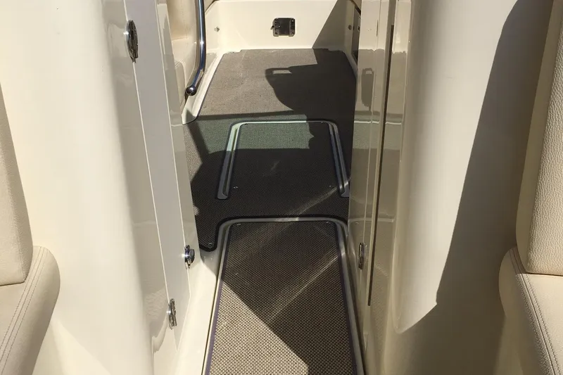 Slide: The Image of 2019 Chris-Craft Launch 27 interior walkway with carpeted flooring. - 26