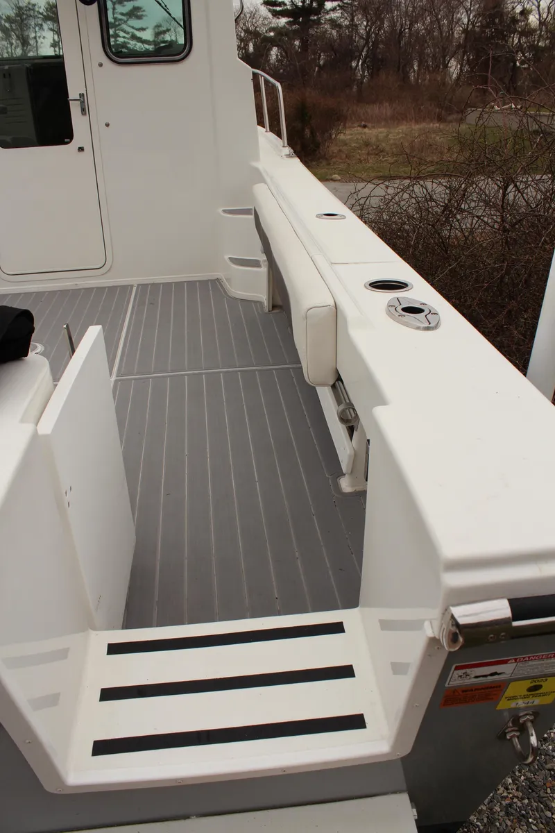 Slide: The Image of 2020 Parker 2520 XL Deep Vee Sport Cabin boat deck with seating and rod holders. - 14