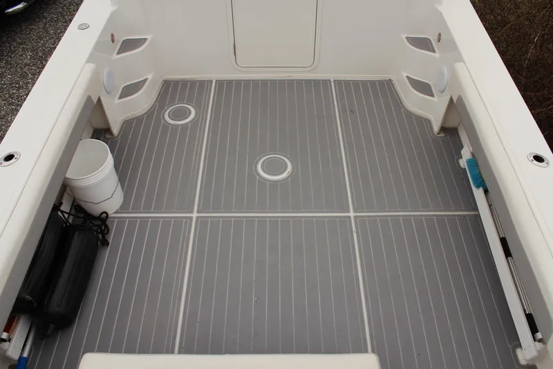 Slide: The Image of 2020 Parker 2520 XL Deep Vee Sport Cabin boat deck with gray flooring and storage compartments. - 16
