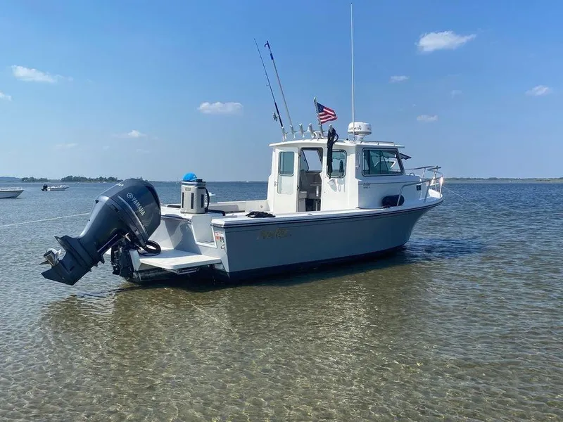 Slide: The Image of 2020 Parker 2520 XL Deep Vee Sport Cabin boat on calm water, clear sky. - 4
