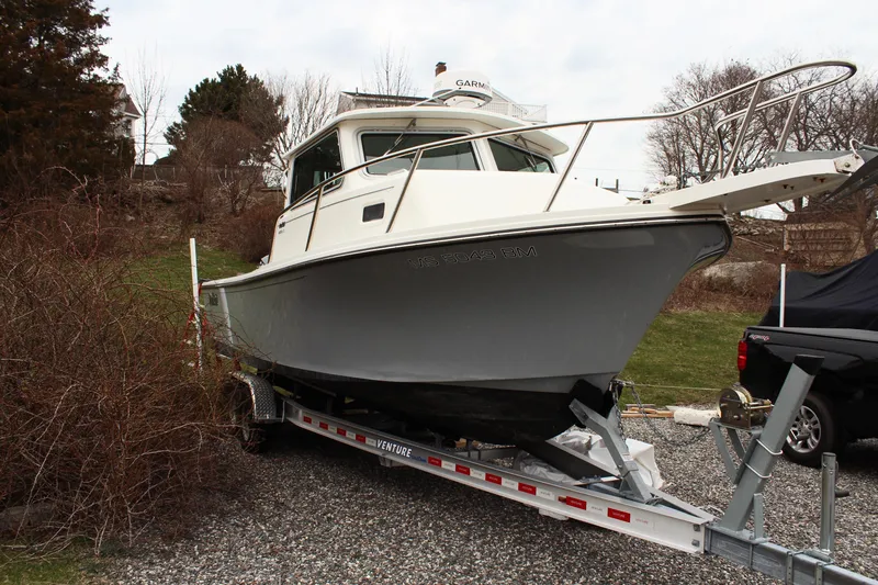 Slide: The Image of 2020 Parker 2520 XL Deep Vee Sport Cabin boat on trailer, parked outdoors. - 9