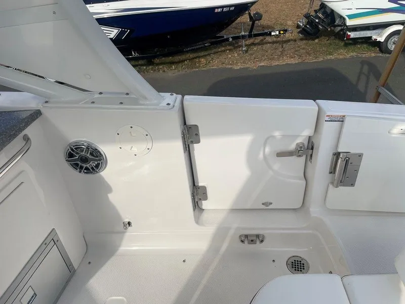 Slide: The Image of 2024 Chaparral 280 OSX boat interior with white deck and storage compartments. - 30
